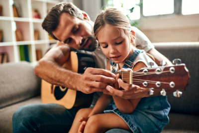 a person and a child playing guitar
